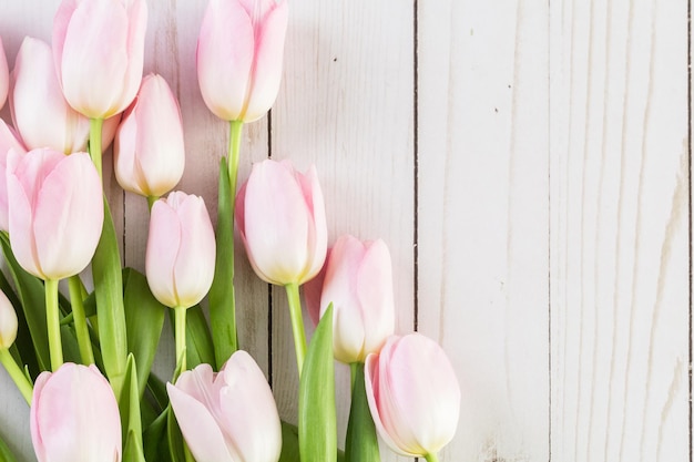 Buquê de tulipas cor de rosa em um fundo de madeira.