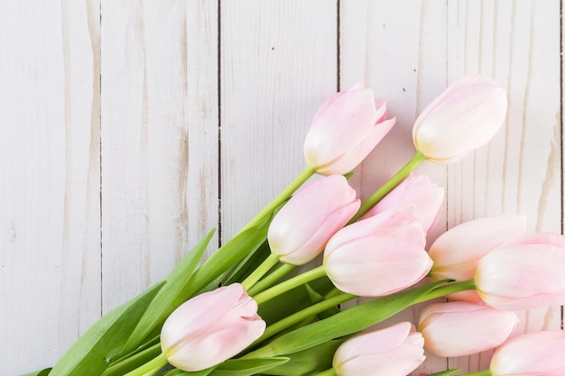 Buquê de tulipas cor de rosa em um fundo de madeira.