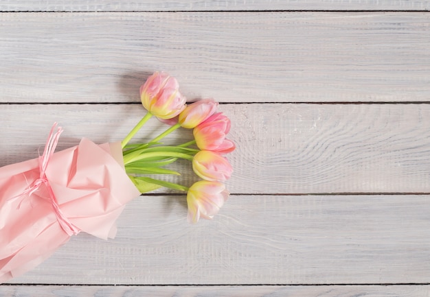 Buquê de tulipas cor de rosa em uma mesa de madeira branca