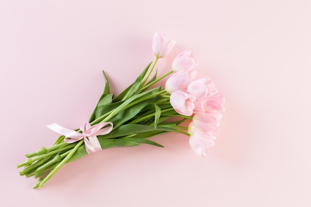 Buquê de tulipas cor de rosa embrulhado em papel rosa.