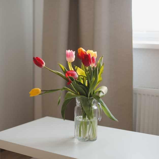 Buquê de tulipas em um vaso sobre a mesa em casa