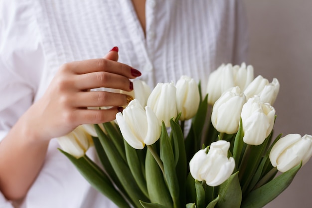 buquê de tulipas nas mãos de um close de menina