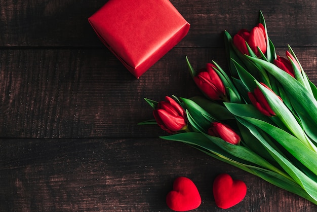 Buquê de tulipas vermelhas em um fundo de madeira.