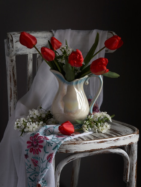 Buquê de tulipas vermelhas em um vaso branco vintage