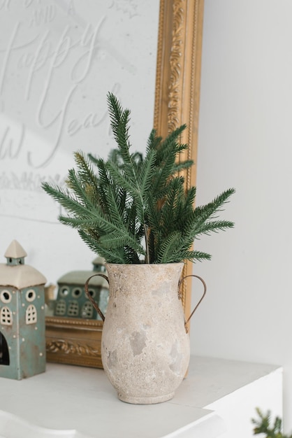 Buquê festivo de inverno de ramos de abeto em um vaso de cerâmica no fundo de um espelho de Natal ou conceito de Ano Novo