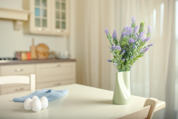 Buquê fresco de flores silvestres em um vaso decorativo em uma mesa de cozinha em casa no início da manhã