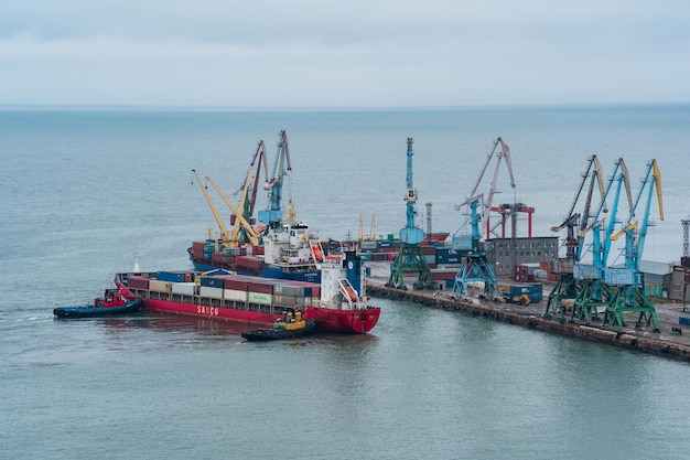 El buque portacontenedores está amarrado con la ayuda de remolcadores a un muelle de carga