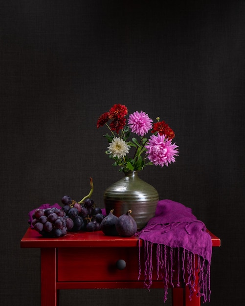 Buquê variado de flores de outono Dálias Fundo escuro Natureza morta com flores e uvas e figos frescos Cartão postal feriado parabéns