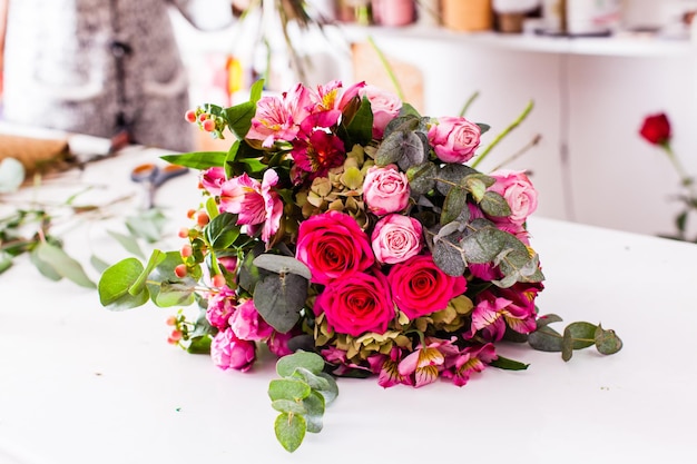 Buquês acabados na mesa da floricultura. Criando as decorações florísticas