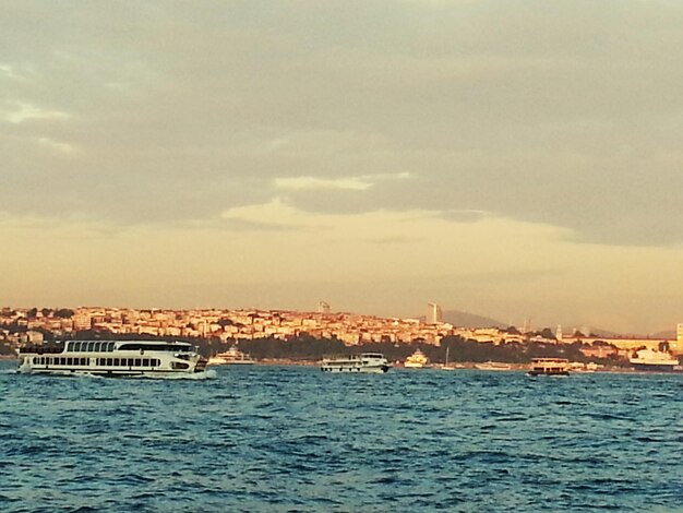 Foto buques de pasajeros en el mar junto a edificios contra el cielo