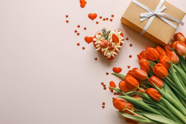 Buquet de pastel de cumpleaños de tulipanes rojos y sobre con carta regalo de vacaciones