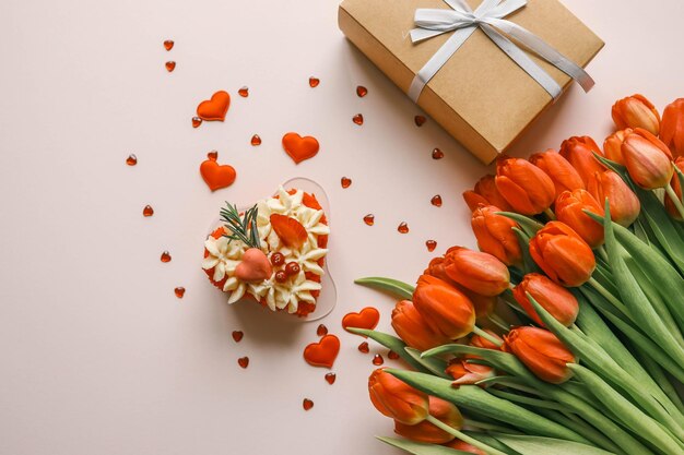 Buquet de pastel de cumpleaños de tulipanes rojos y sobre con carta regalo de vacaciones