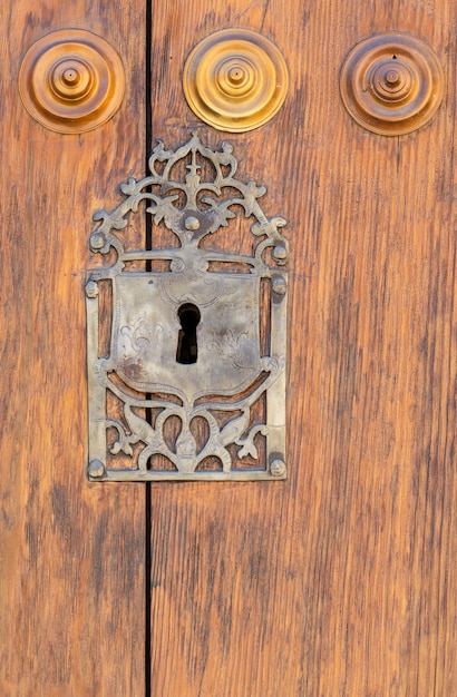 Buraco da fechadura em uma porta de madeira apainelada velha; enferrujado e intemperizado