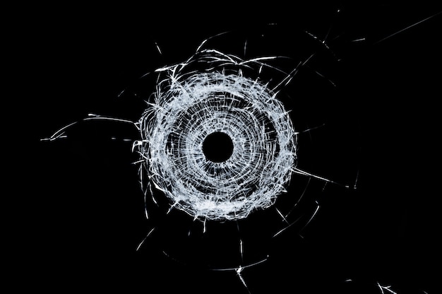 Buraco de bala de vidro quebrado único em vidro isolado no preto
