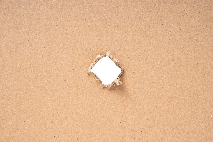Foto buraco rasgado no papelão no fundo branco