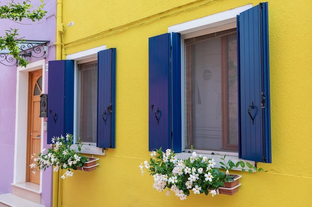 Burano, Veneza, Itália - 2 de julho de 2018: vista panorâmica de casas coloridas de Burano é uma ilha na lagoa veneziana. As pessoas caminham e descansam nas ruas. Dia ensolarado de verão e céu azul