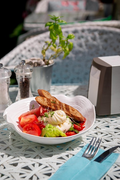 Burato-Käse und rote Tomate mit Croutons-Brunnenkresse-Salat und anderen grünen Kräutern