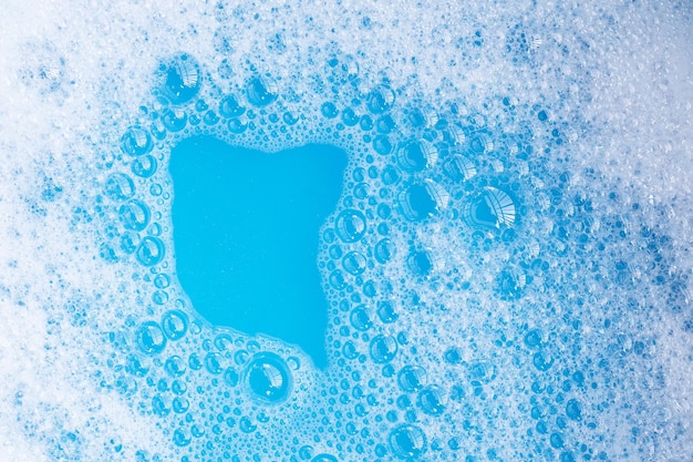 Foto burbuja de espuma de detergente fondo azul.