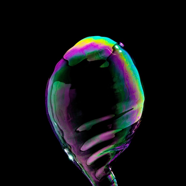 Burbuja de jabón en colores coloridos sobre fondo negro