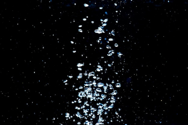 Burbujas de agua aisladas en fondo negro vista de cerca Superficie líquida ondulada un fondo abstracto para el diseño de superposiciones