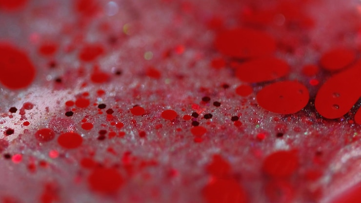 Foto burbujas brillantes mezcla de pintura brillante borrosa color rojo partículas de pañuelo brillante gotas de tinta gel transparente