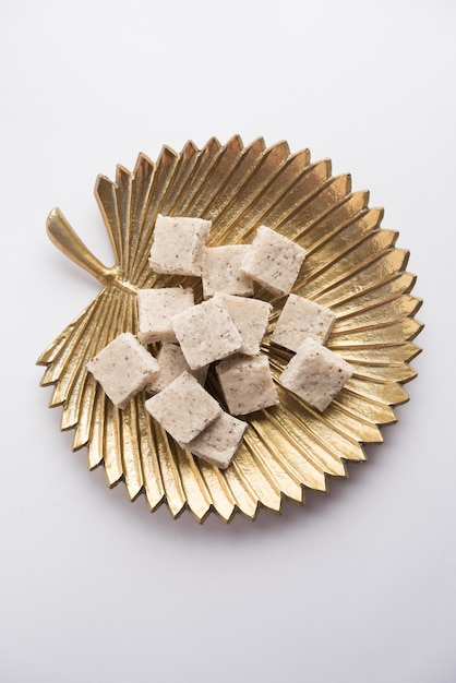 Burfi de coco ou Nariyal Barfi é um bolo doce servido em um prato com foco seletivo