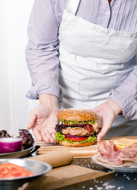 Burger Cheeseburger Hamburger großer Chif Koch, der weißen Hintergrund nach Hause kocht