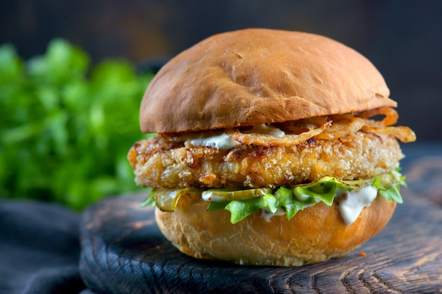 Foto burger de peixe com cebola frita e molho