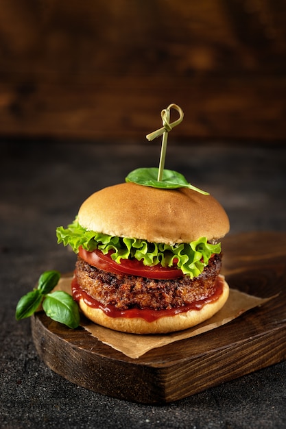 Burger des strengen Vegetariers auf dunkler rustikaler brauner Oberfläche