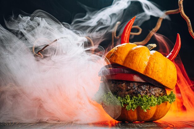 Foto burger halloween halloween conceito de um hambúrguer com grandes rissóis de carne com rolos de cabeça de abóbora para o feriado de halloween