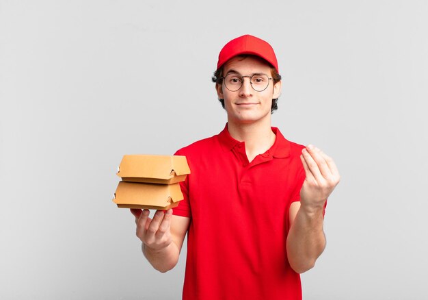 Burger liefern Jungen, die eine Capice- oder Geldgeste machen und Ihnen sagen, dass Sie Ihre Schulden bezahlen sollen!