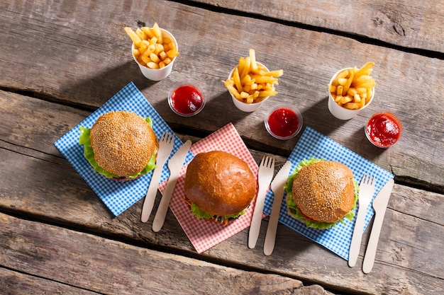 Burger mit Besteck und Pommes.