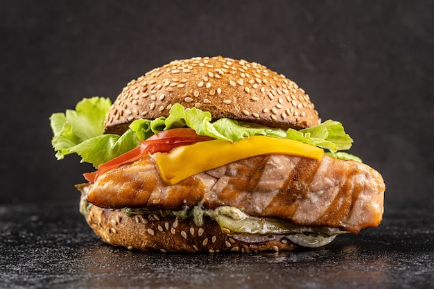 Burger mit einem großen gebratenen Stück rotem Lachs