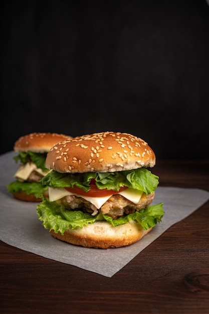 Burger mit Hühnerschnitzel, Käse, Tomaten und Kräutern.