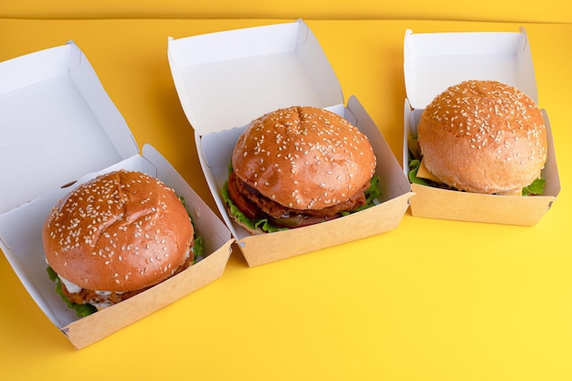 Burger mit Huhn auf einem hellen Hintergrund des gelben Hintergrundes