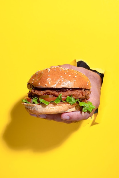 Burger mit Huhn auf einem hellen Hintergrund des gelben Hintergrundes