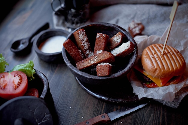 Burger mit Knoblauchcroutons im dunklen Innenraum der Kneipe Deftiges schnelles MittagessenAtmosphärisches Foto