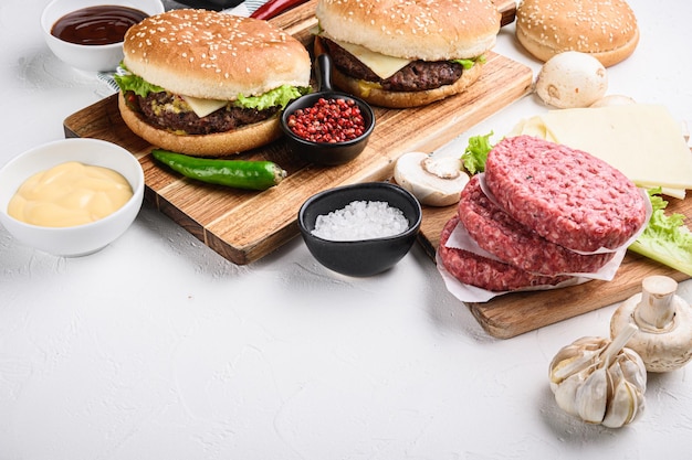 Burger mit Rindfleisch zum Grillen auf weißem Hintergrund mit Kopienraum.