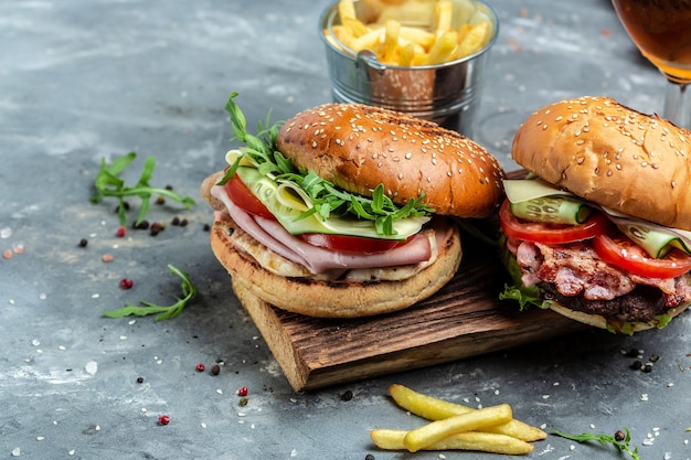 Burger mit Schinken, Käse, Speck, Salat und Gemüse. Großer Burger, amerikanisches Fastfood. Banner, Menü, Rezeptplatz für Text