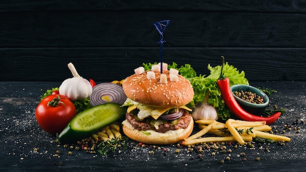 Burger mit Schmalzkalbskäse und Salat American Traditional Food auf schwarzem Holzhintergrund Kopierbereich