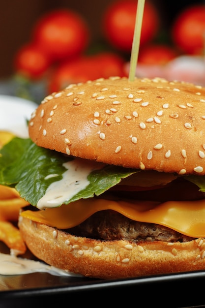 Burger mit Schnitzel, Käse und Tomaten.