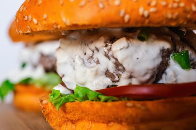 Burger mit Sesambrötchen auf Holzbrett