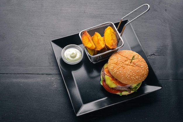Burger und Kartoffeln mit Soße Auf einem hölzernen Hintergrund Ansicht von oben Freier Platz für Ihren Text