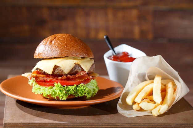 Burger und Pommes auf dem Holztisch.