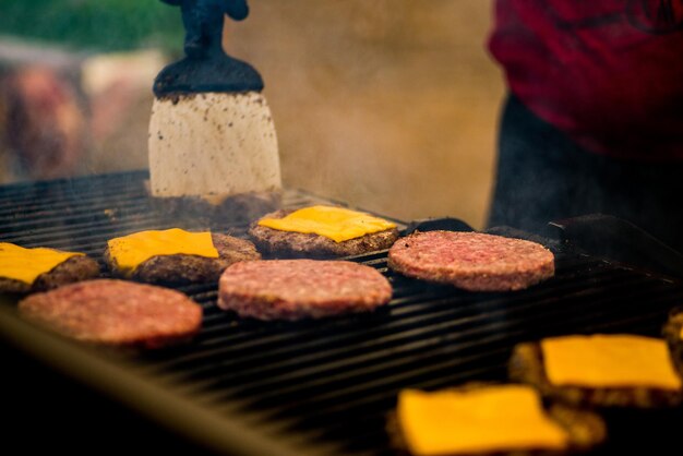 Burgerschnitzel werden gegrillt. Picknick mit Burgern. Holzkohlegrill