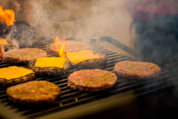 Burgerschnitzel werden gegrillt. Picknick mit Burgern. Holzkohlegrill