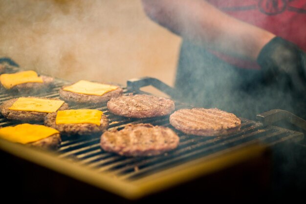 Burgerschnitzel werden gegrillt. Picknick mit Burgern. Holzkohlegrill