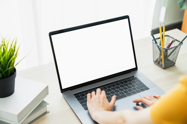 Burlarse de la mano de la mujer usando la computadora portátil y tocar el teclado.