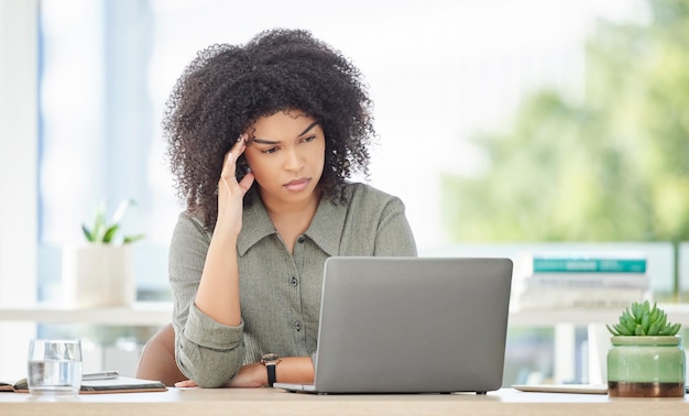 Burnout do laptop do escritório e mulher negra lendo comentários sobre a experiência do cliente nas mídias sociais ou site de comércio eletrônico Dor de cabeça de saúde mental e funcionário cansado da análise da pesquisa on-line