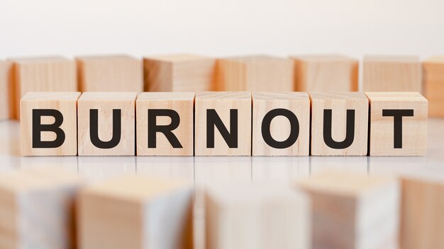 Burnout - letras de madera en el escritorio de oficina, fondo blanco, concepto de negocio